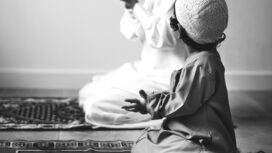 Muslim boy learning how to make Dua to Allah