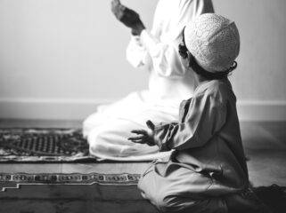 Muslim boy learning how to make Dua to Allah