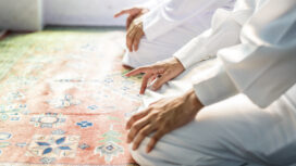 Muslim men praying in Tashahhud posture